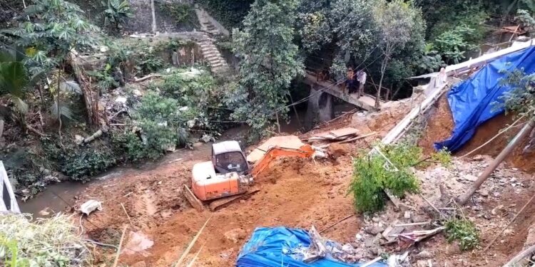 Longsor kembali terjadi di Jalan Raya Tajur, Muarasari, Kota Bogor. Material tanah menimbun alat berat, sementara petugas mengantisipasi longsor susulan.